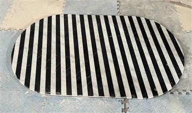 Tauleta de cafè de forma ovalada amb tires de marbre blanc i negre